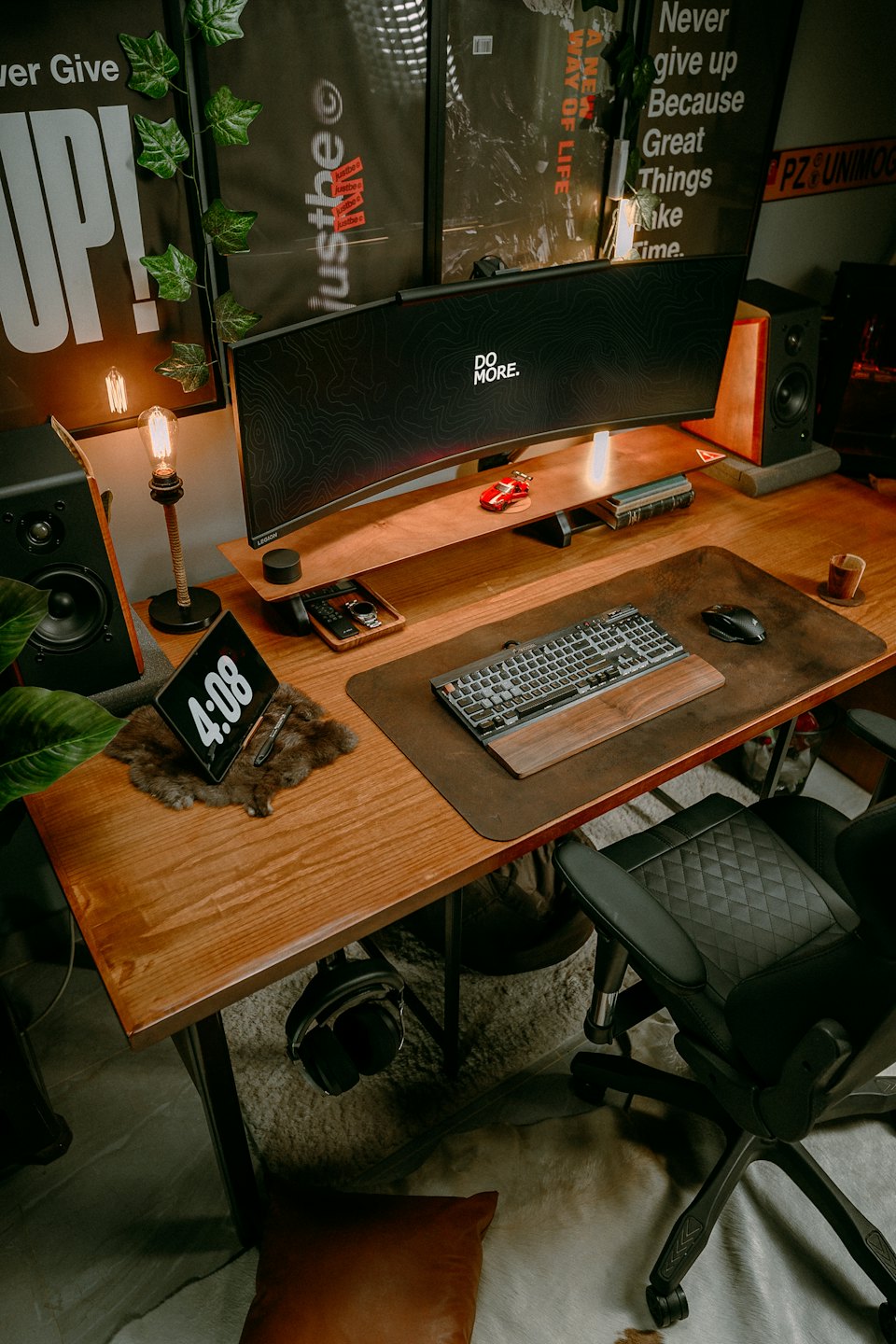 Modern wooden desk with a large curved monitor and computer equipment.
